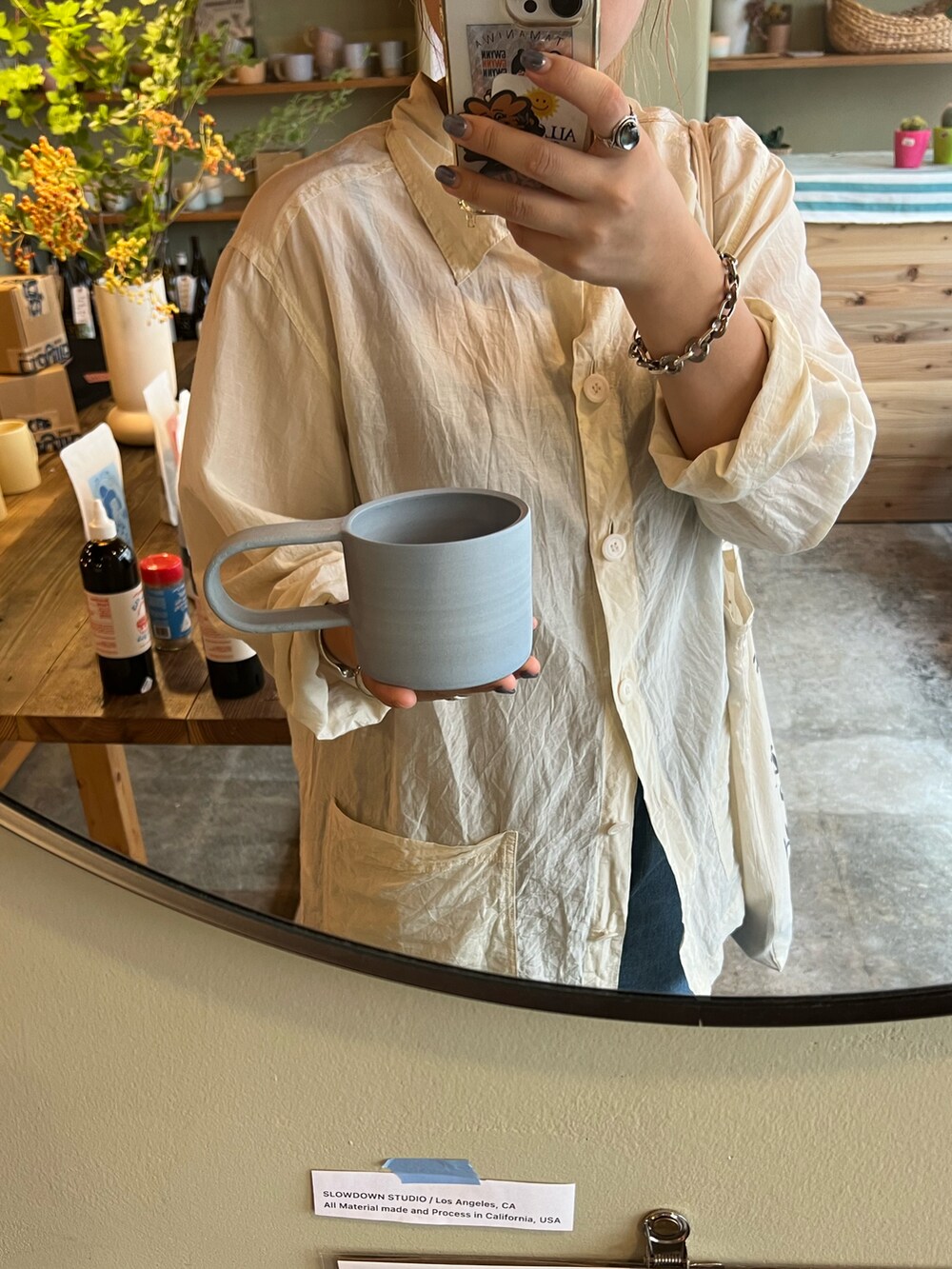 ホワイト系のシャツ/ブラウス、ブルー系のデニムパンツ、ブラウン系のスニーカーを着用したレディースの秋コーディネートの3枚目の写真