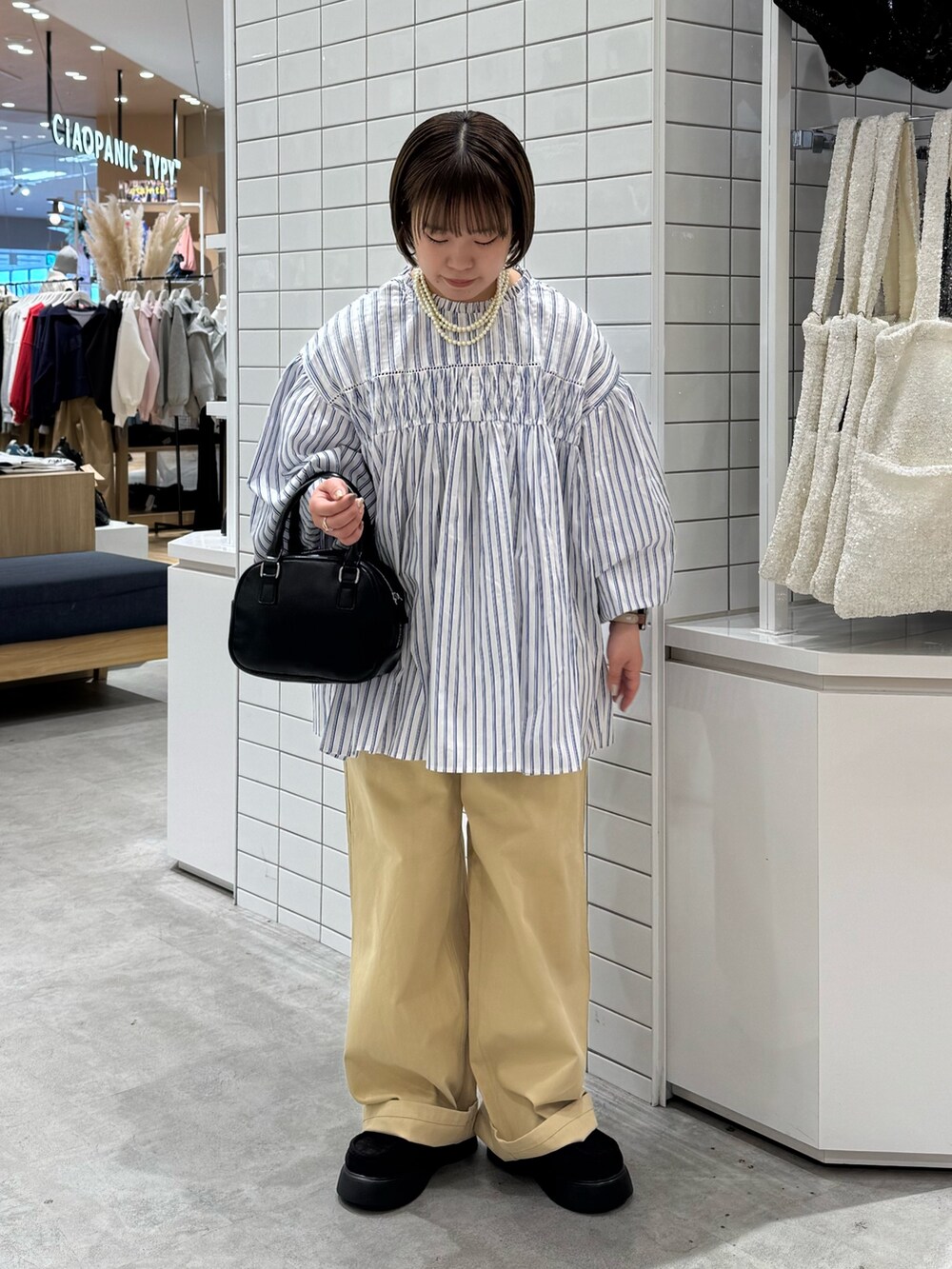 ブルー系のシャツ/ブラウス、ベージュ系のチノパンツ、ブラック系のサンダルを着用したレディースの春コーディネートの2枚目の写真