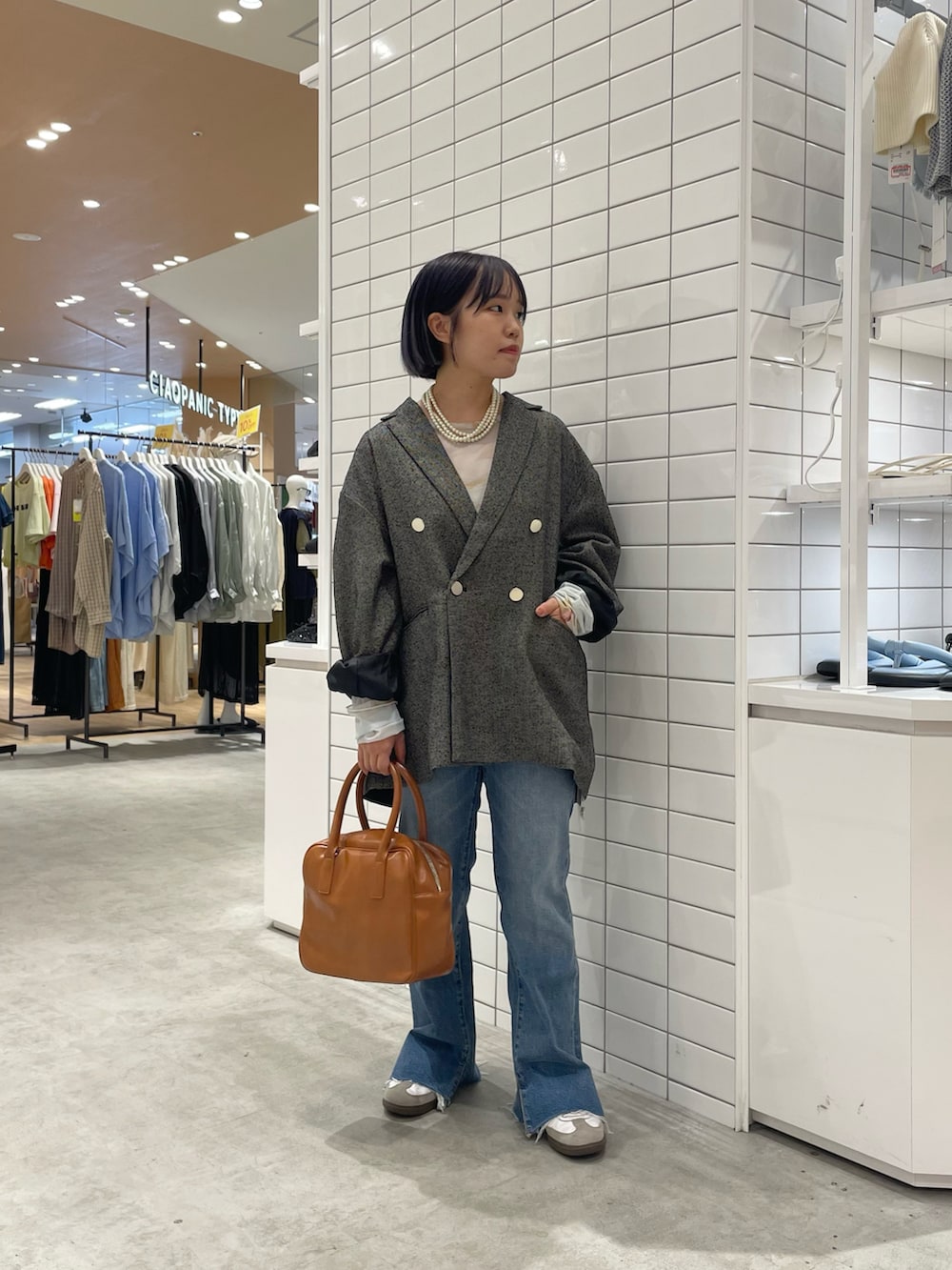 ホワイト系のスニーカー、ホワイト系のTシャツ/カットソー、ブラック系のテーラードジャケットを着用したレディースの秋コーディネートの3枚目の写真