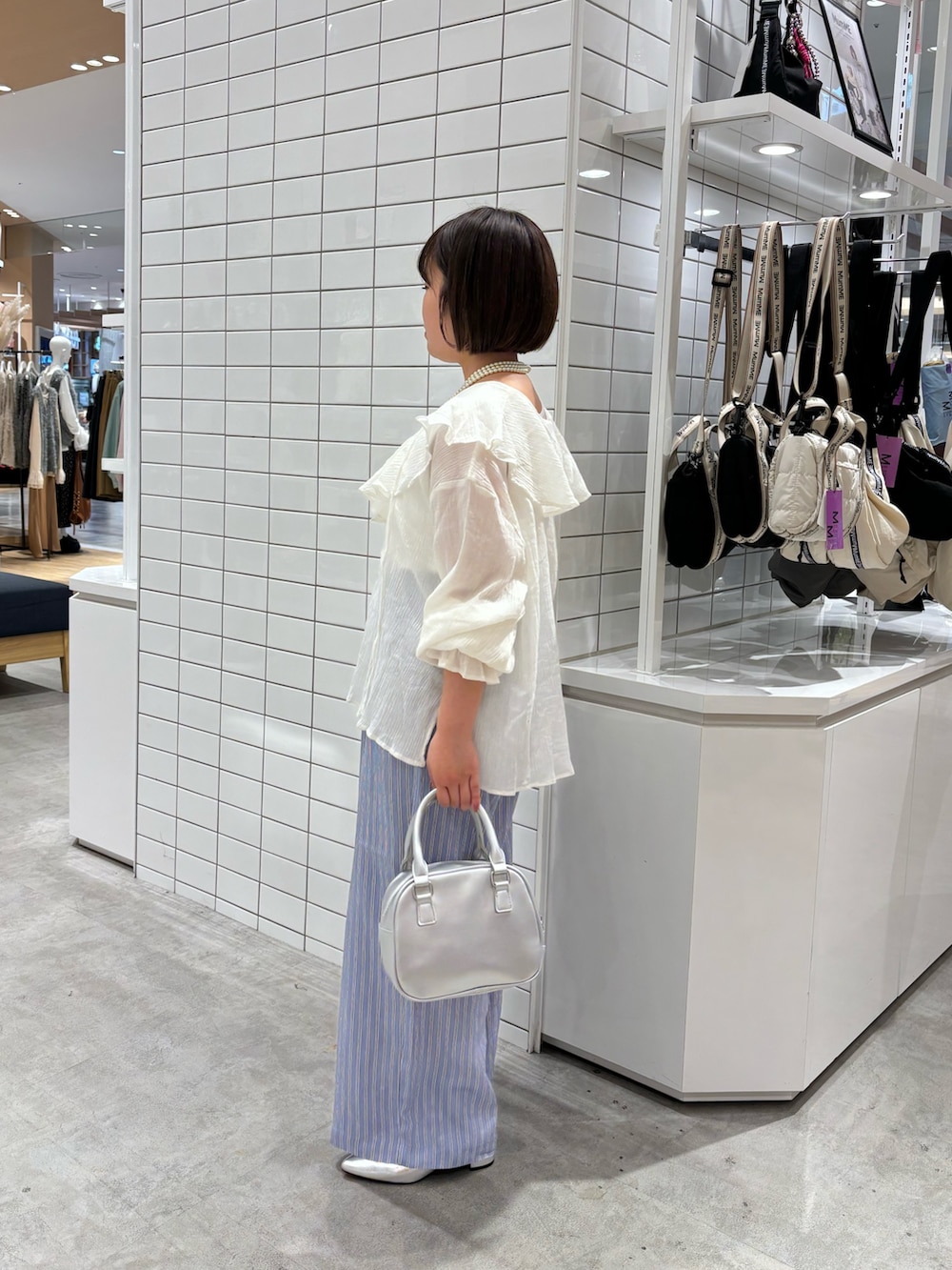 ホワイト系のタンクトップ、ホワイト系のシャツ/ブラウス、シルバー系のショルダーバッグを着用したレディースの春コーディネートの2枚目の写真