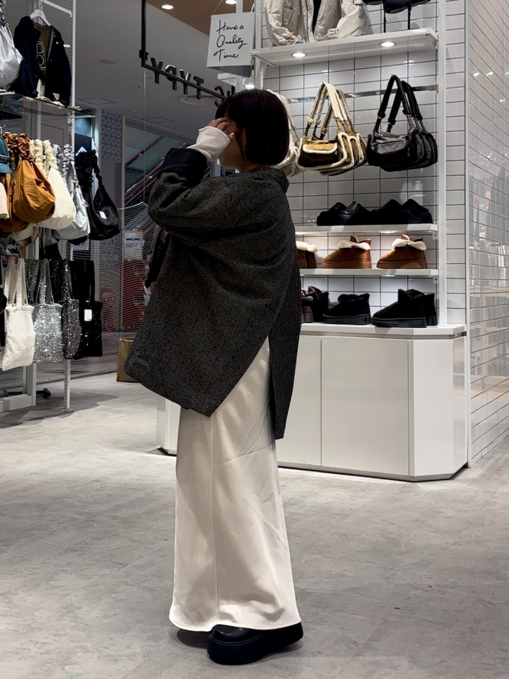 ホワイト系のスカート、ブラック系のブーツ、ホワイト系のTシャツ/カットソーを着用したレディースの秋コーディネートの4枚目の写真