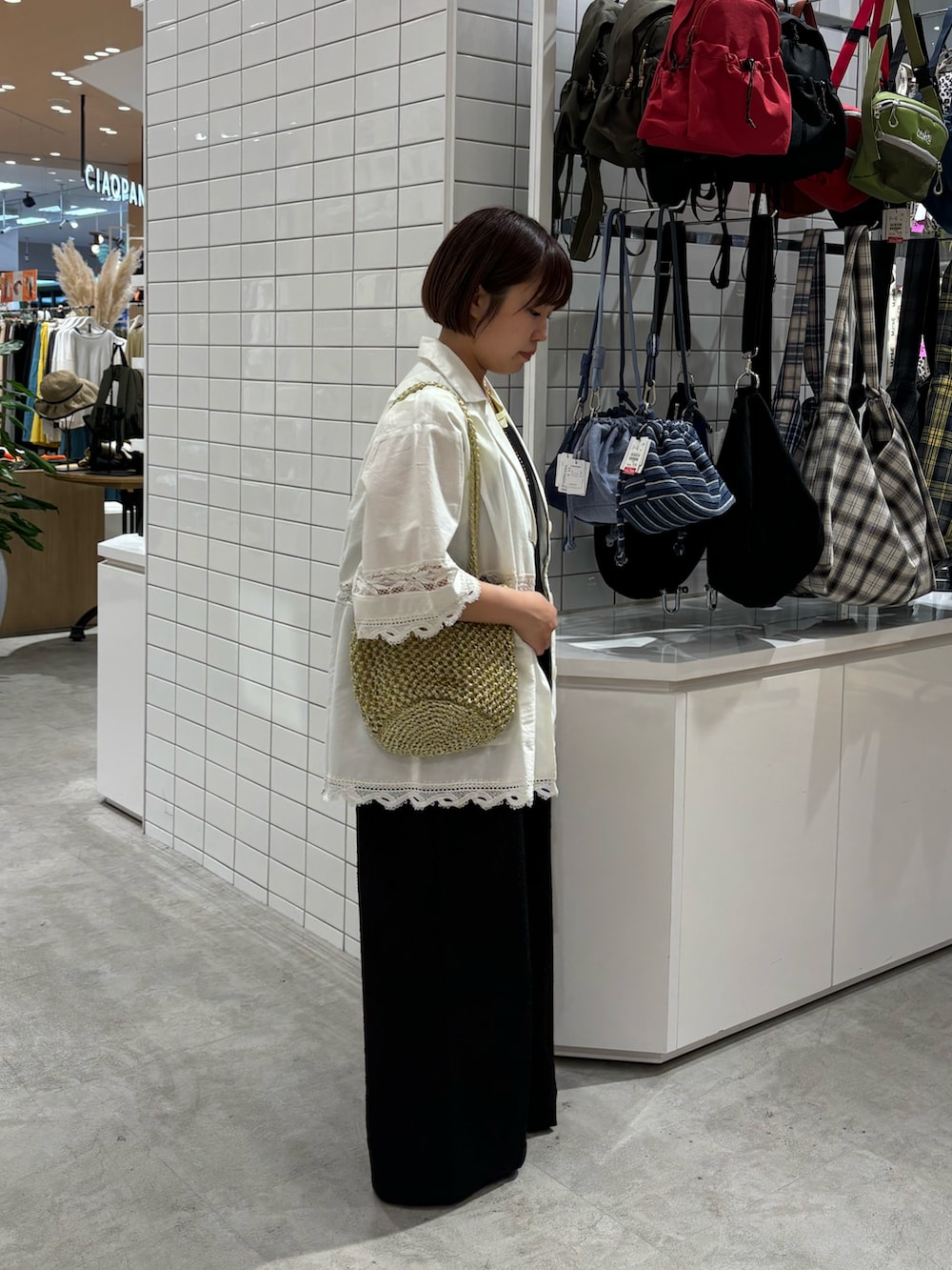 ホワイト系のシャツ/ブラウス、ブラック系のサロペット/オーバーオール、ブラウン系のサンダルを着用したレディースの夏コーディネートの2枚目の写真