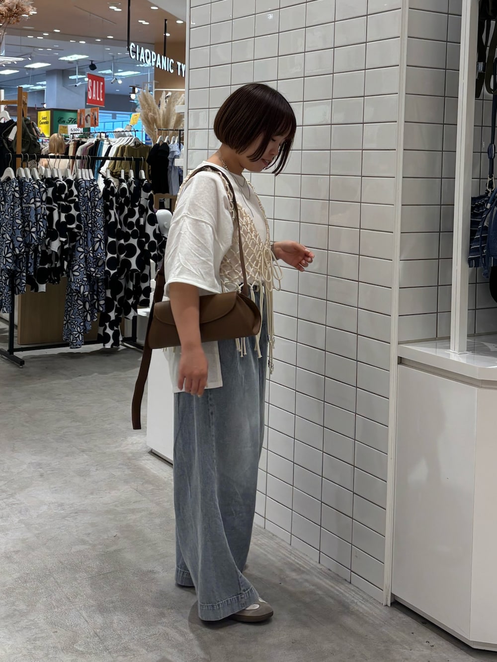 ブルー系のデニムパンツ、ホワイト系のベスト、ピンク系のタンクトップを着用したレディースの夏コーディネートの2枚目の写真