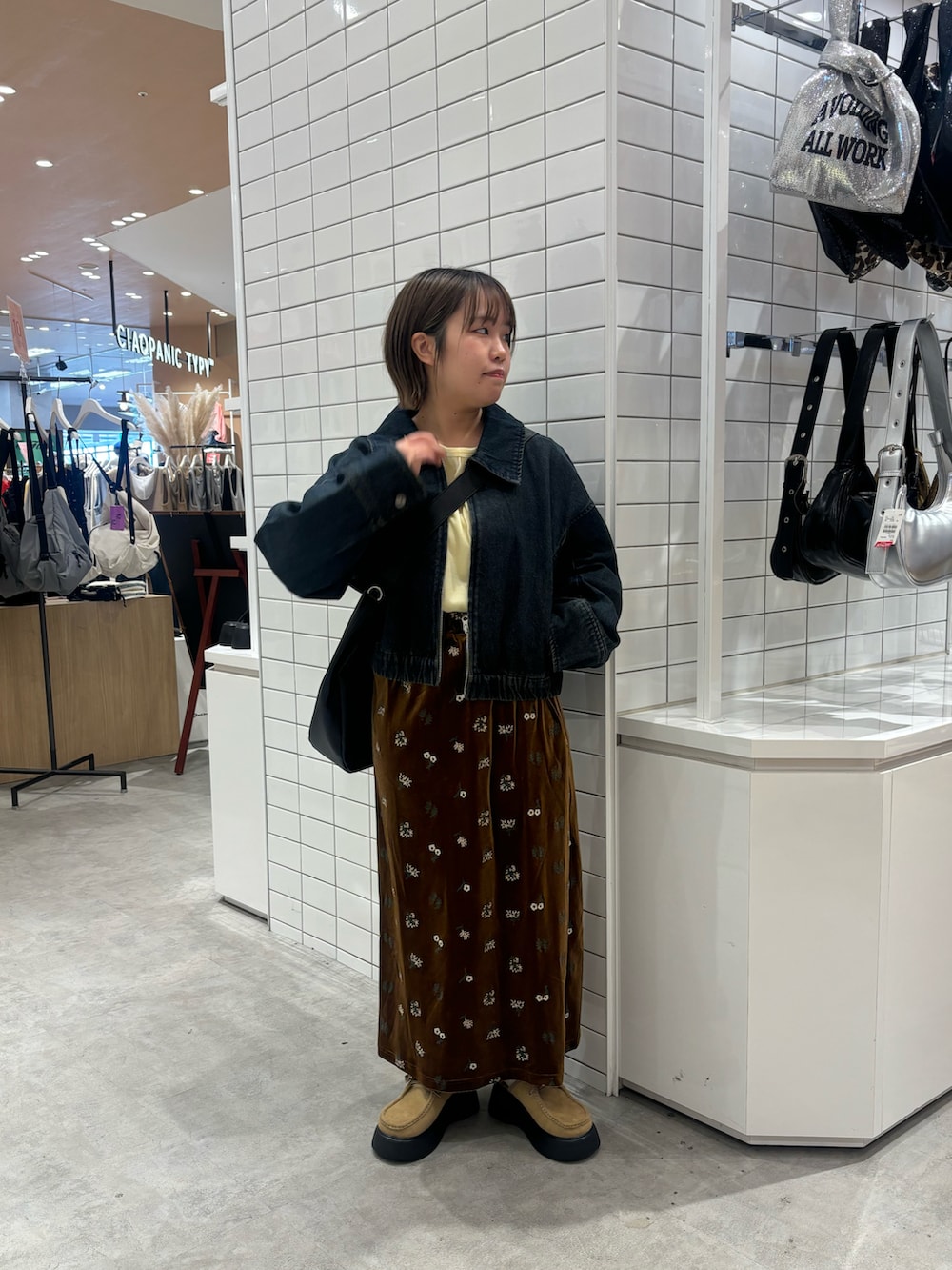 イエロー系のTシャツ/カットソー、ブルー系のデニムジャケット、ブラック系のスカートを着用したレディースの春コーディネートの2枚目の写真