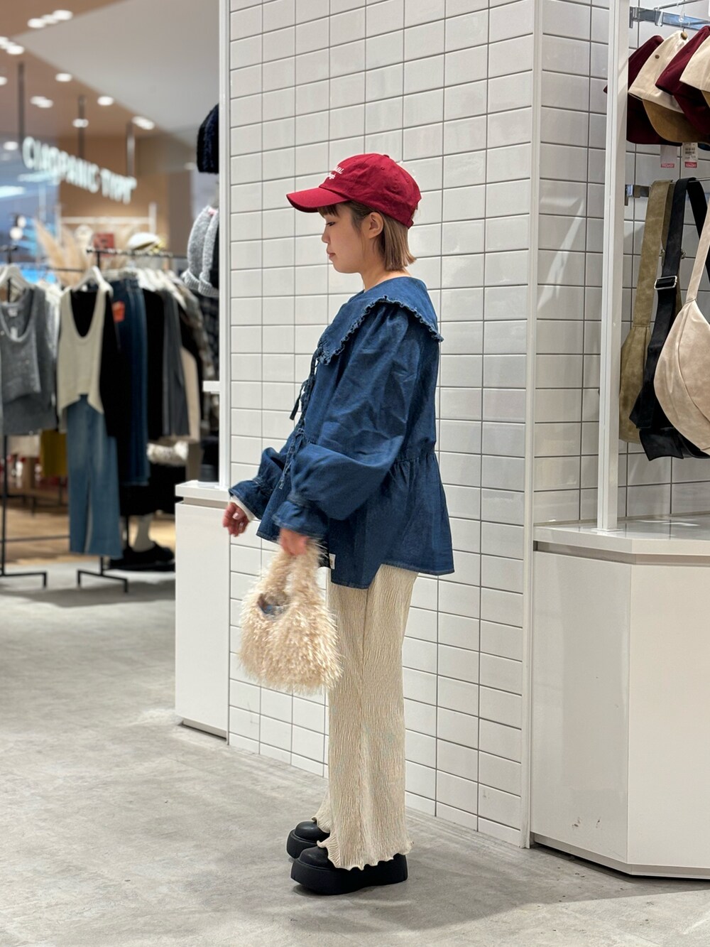 ブラック系のブーツ、ホワイト系のその他パンツ、ホワイト系のトートバッグを着用したレディースの冬コーディネートの2枚目の写真