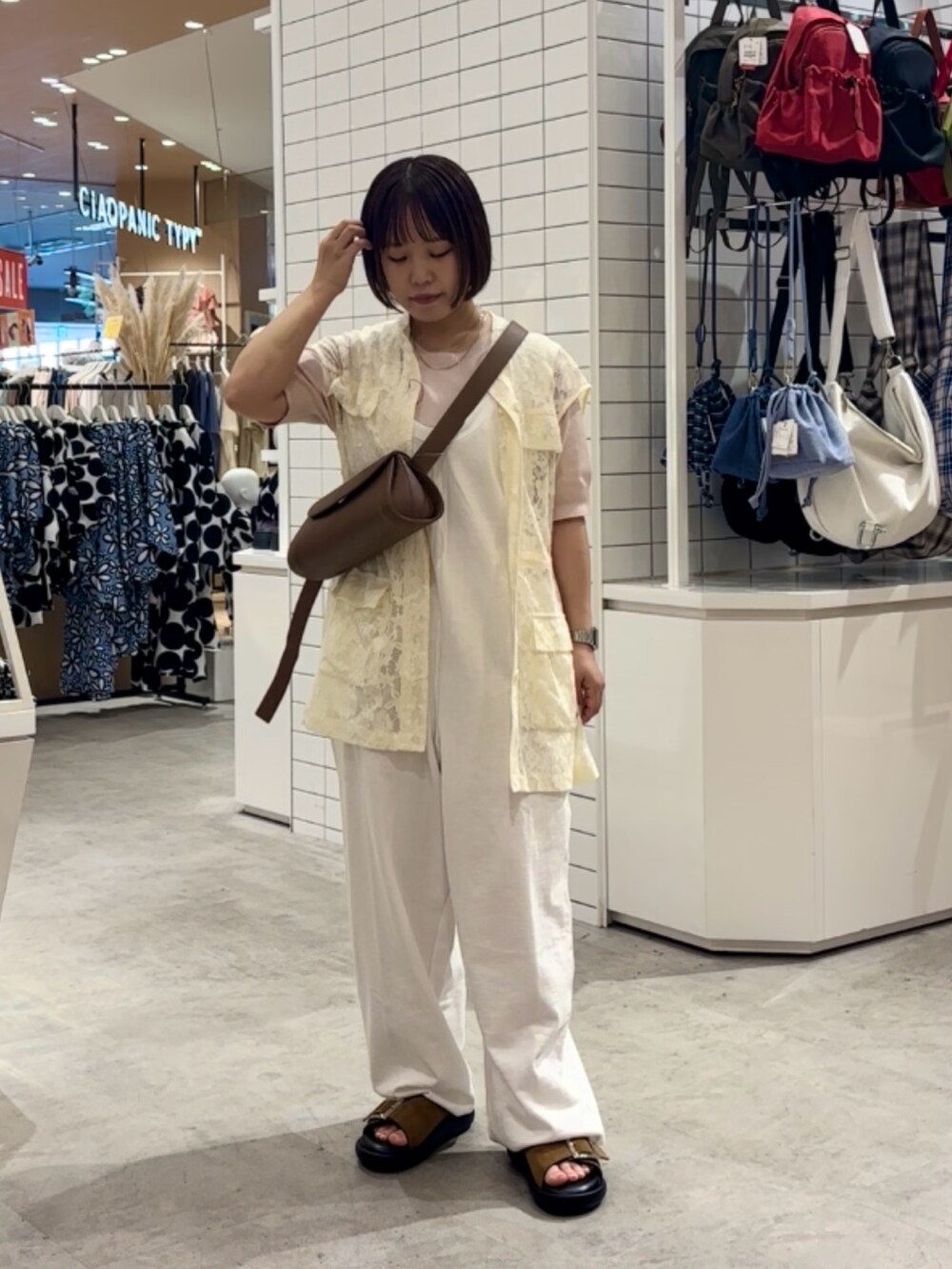 ホワイト系のサロペット/オーバーオール、ブラウン系のサンダル、ホワイト系のベストを着用したレディースの夏コーディネートの2枚目の写真