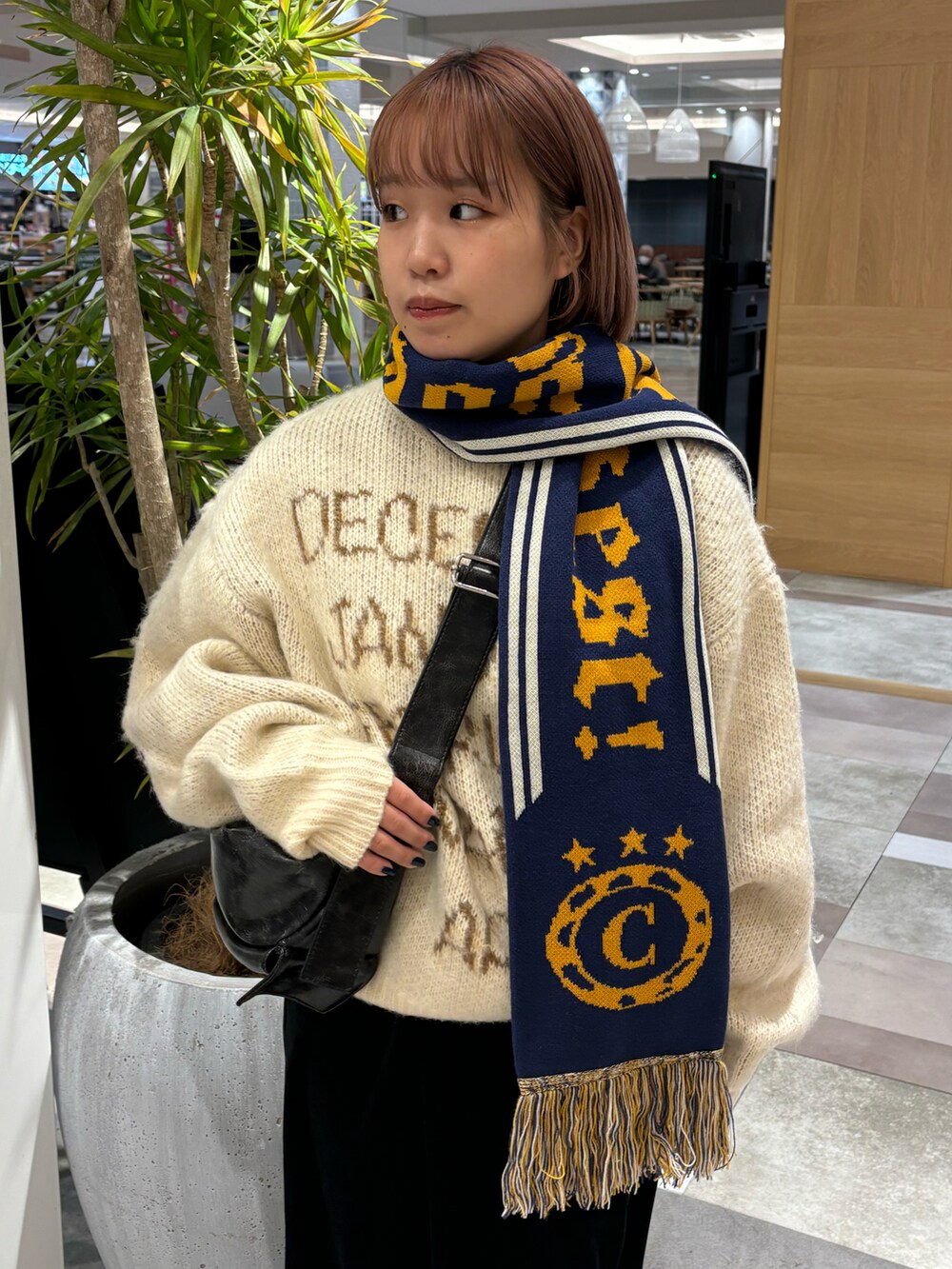 ベージュ系のニット/セーター、ブラック系のショルダーバッグ、ブラック系のパンツを着用したレディースの秋コーディネートの4枚目の写真
