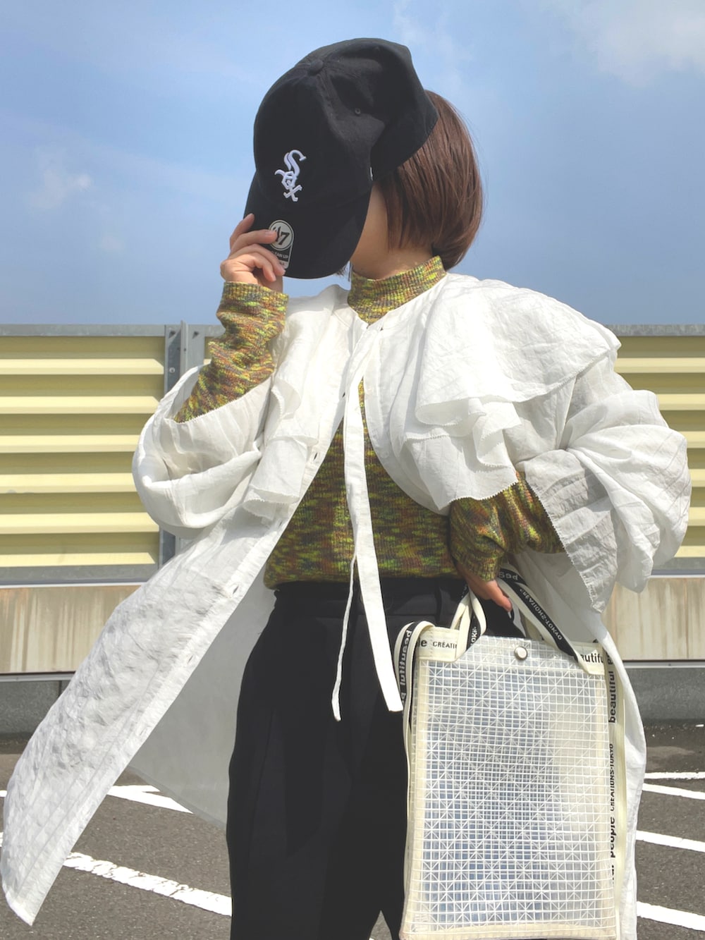 ベージュ系のスニーカー、ブラック系のスラックス、その他のショルダーバッグを着用したレディースの春コーディネートの3枚目の写真