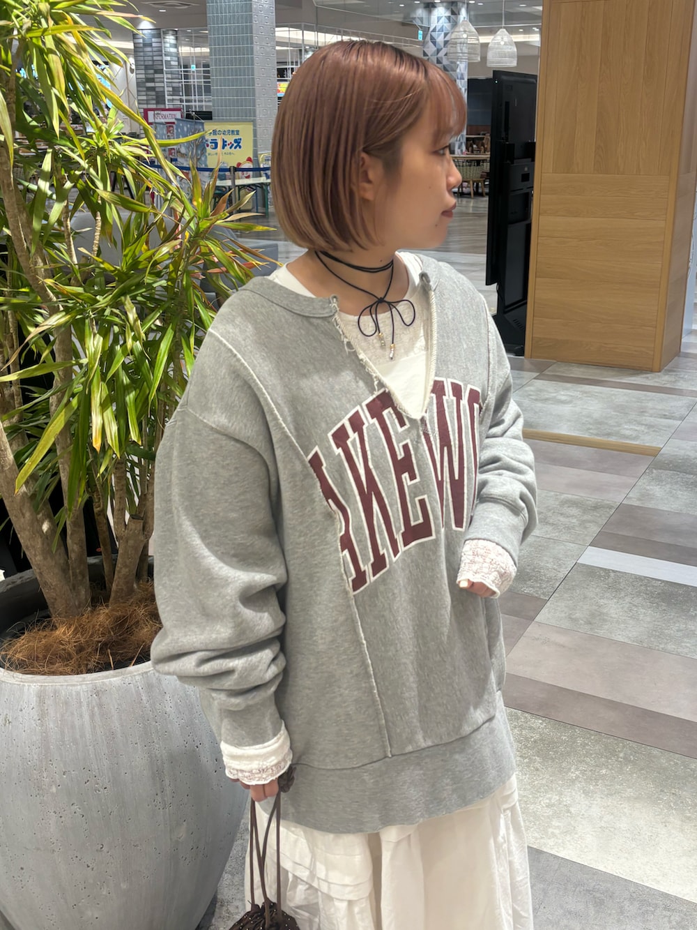 ブラウン系のショルダーバッグ、ホワイト系のワンピース、グレー系のスウェットを着用したレディースの冬コーディネートの5枚目の写真