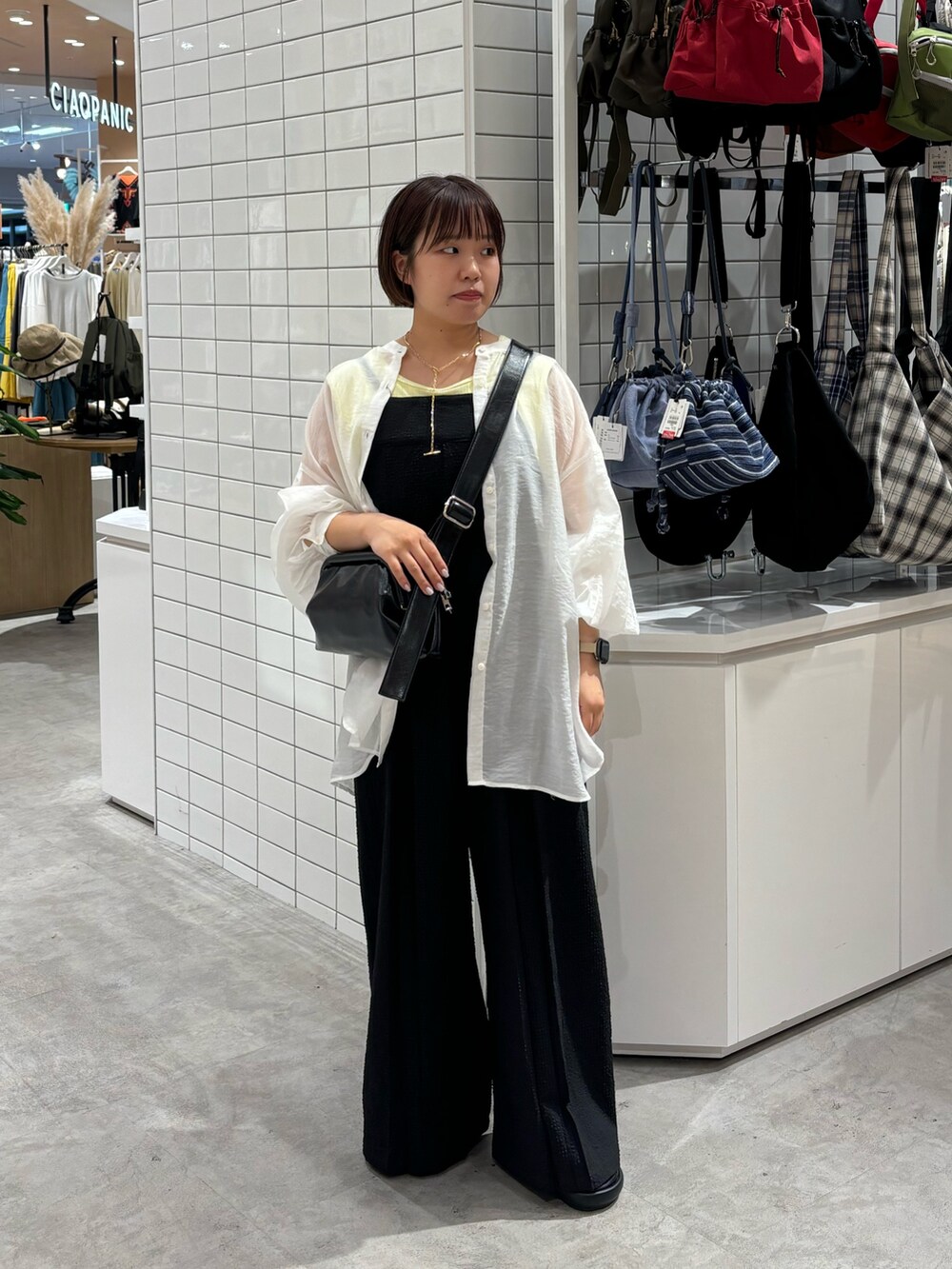 ホワイト系のシャツ/ブラウス、イエロー系のタンクトップ、ブラック系のサロペット/オーバーオールを着用したレディースの夏コーディネートの2枚目の写真