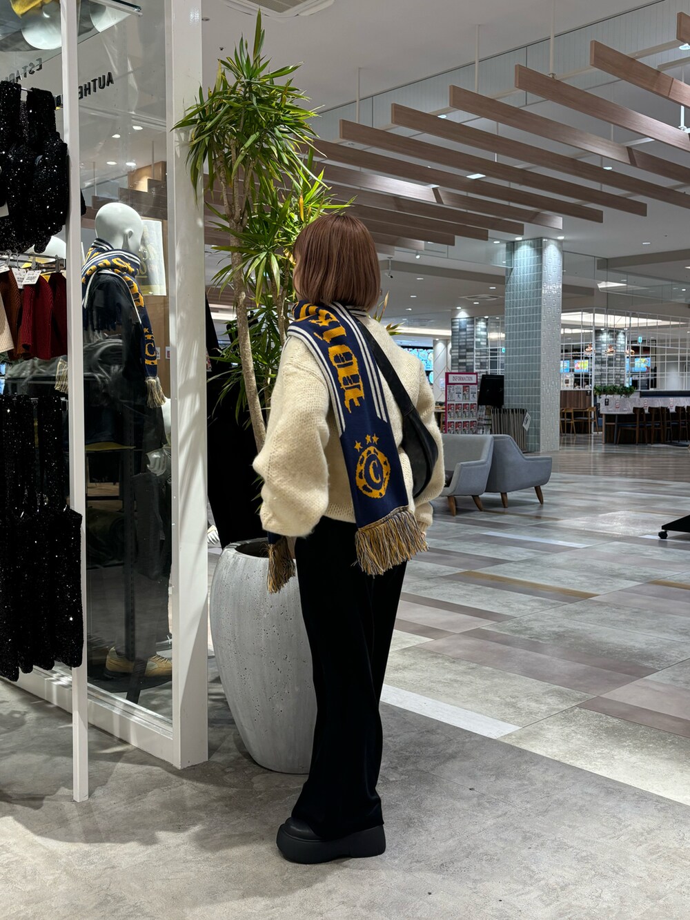 ベージュ系のニット/セーター、ブラック系のショルダーバッグ、ブラック系のパンツを着用したレディースの秋コーディネートの3枚目の写真