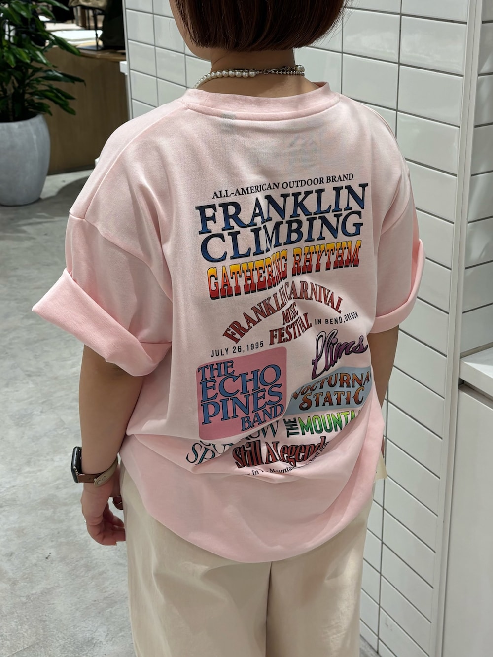 ピンク系のTシャツ/カットソー、ブラック系のトートバッグ、ホワイト系のデニムパンツを着用したレディースの夏コーディネートの2枚目の写真