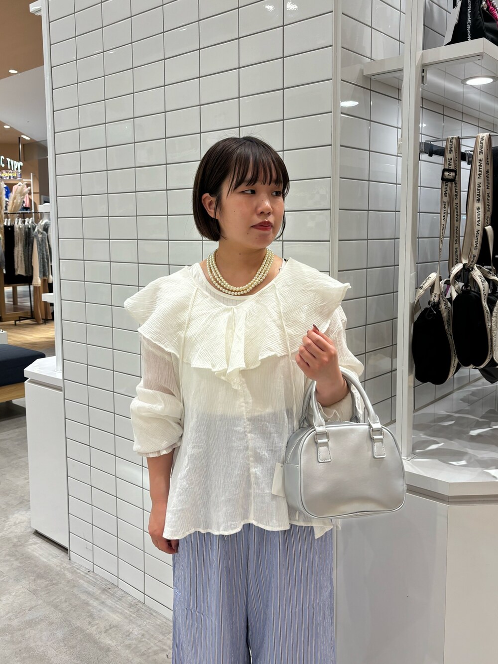ホワイト系のタンクトップ、ホワイト系のシャツ/ブラウス、シルバー系のショルダーバッグを着用したレディースの春コーディネートの3枚目の写真