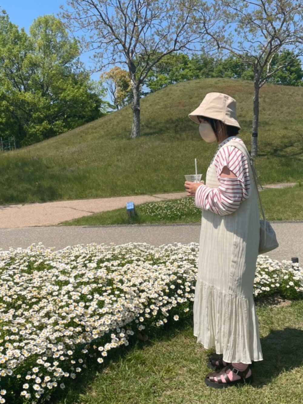 レッド系のTシャツ/カットソー、ホワイト系のワンピース、ホワイト系のショルダーバッグを着用したレディースの春コーディネートの2枚目の写真