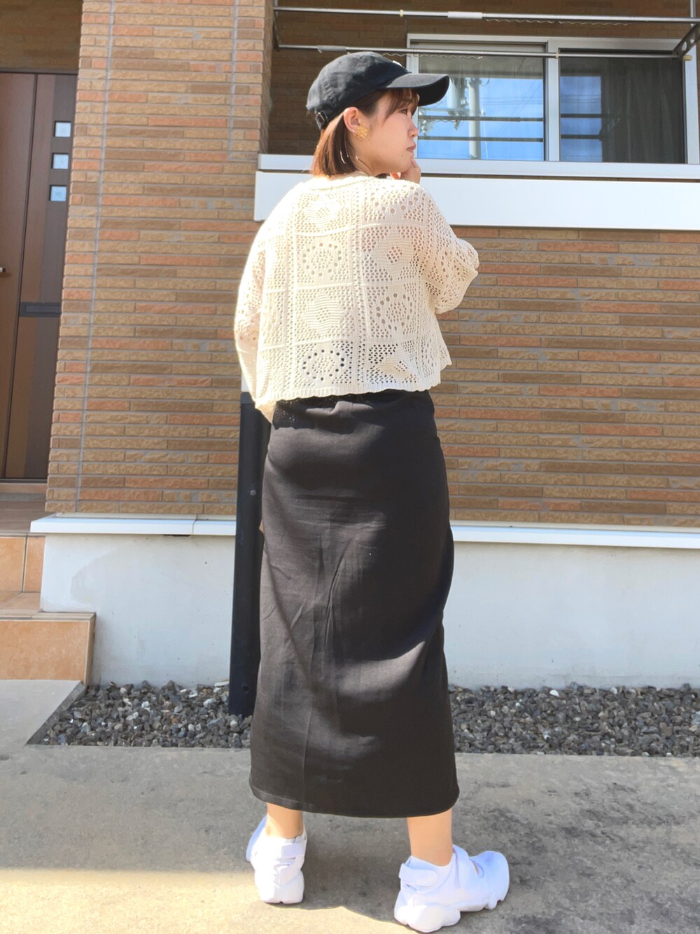 ベージュ系のニット/セーター、ブラック系のスカート、ブラウン系のベストを着用したレディースの春コーディネートの5枚目の写真