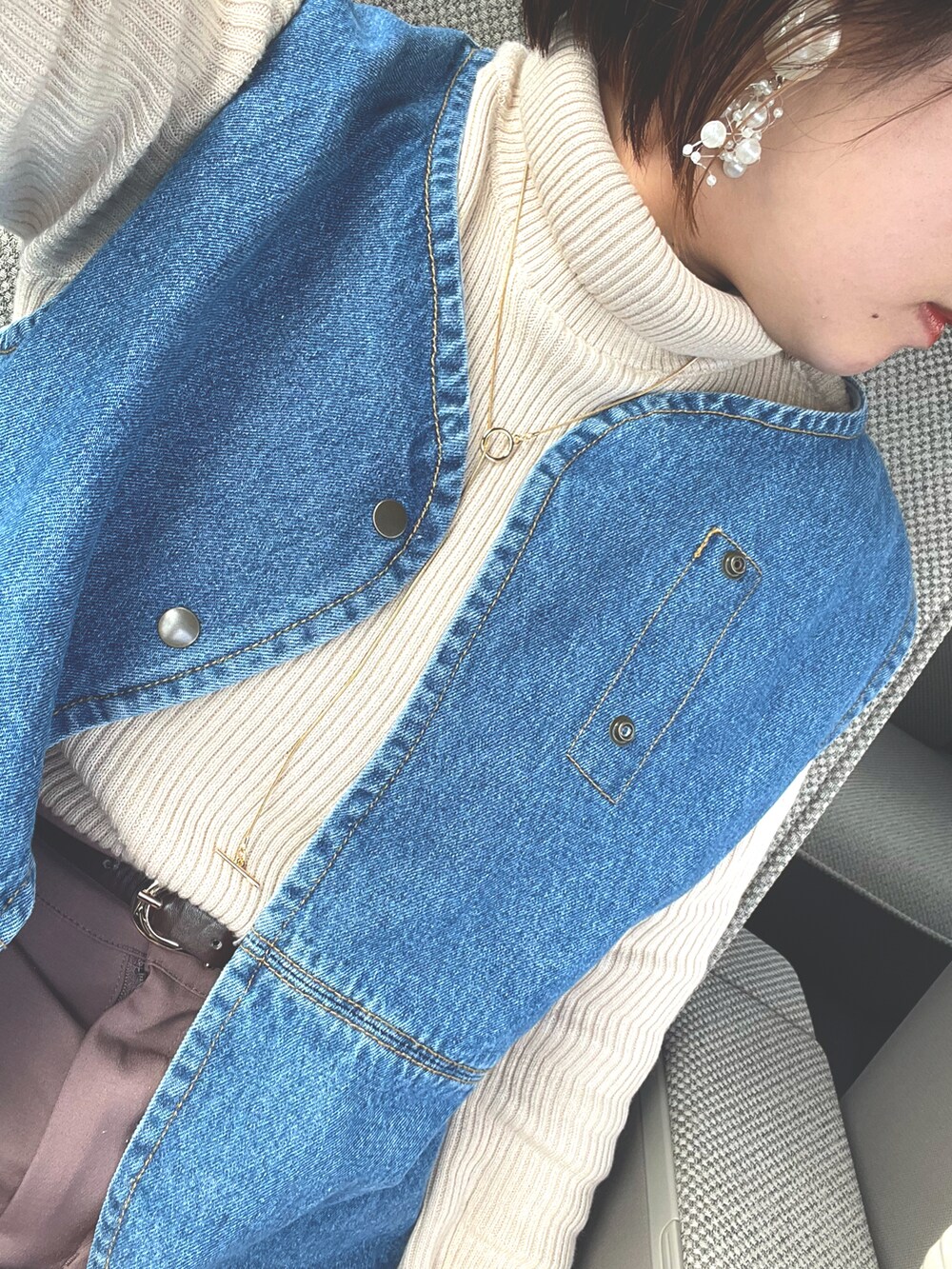 ホワイト系のニット/セーター、ブルー系のベスト、その他のショルダーバッグを着用したレディースの冬コーディネートの4枚目の写真