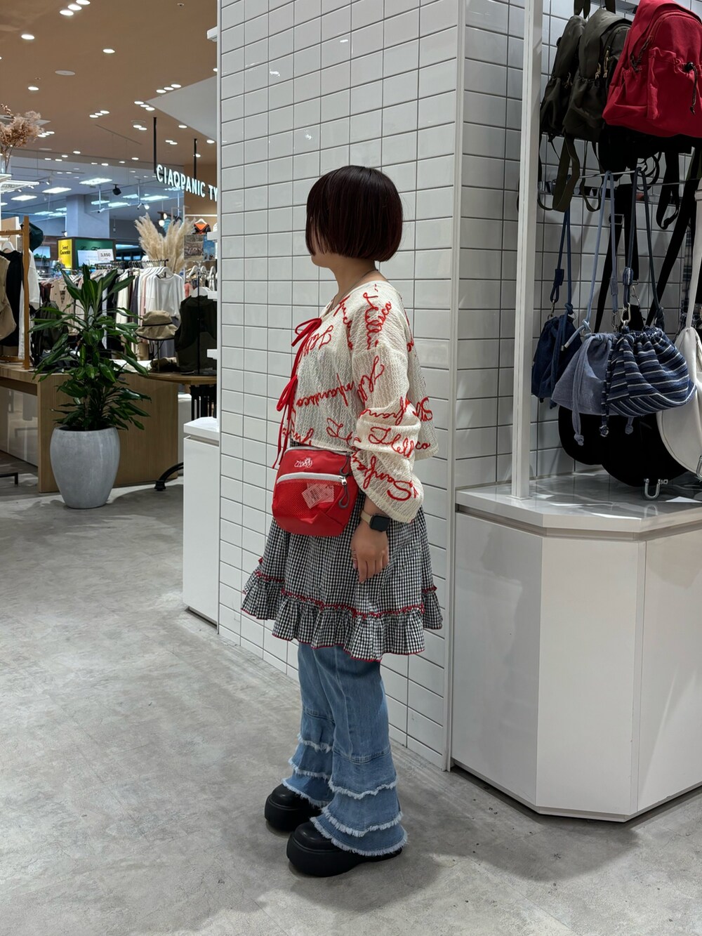 ブルー系のデニムパンツ、ブラック系のワンピース、ホワイト系のTシャツ/カットソーを着用したレディースの夏コーディネートの2枚目の写真