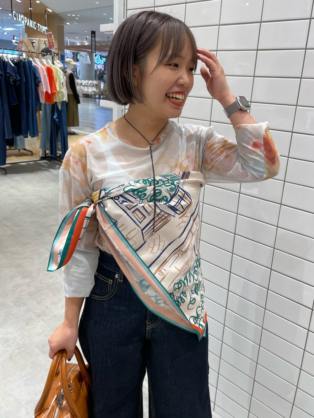 ホワイト系のTシャツ/カットソー、ブルー系のデニムパンツ、ブラウン系のボストンバッグを着用したレディースの秋コーディネートの2枚目の写真