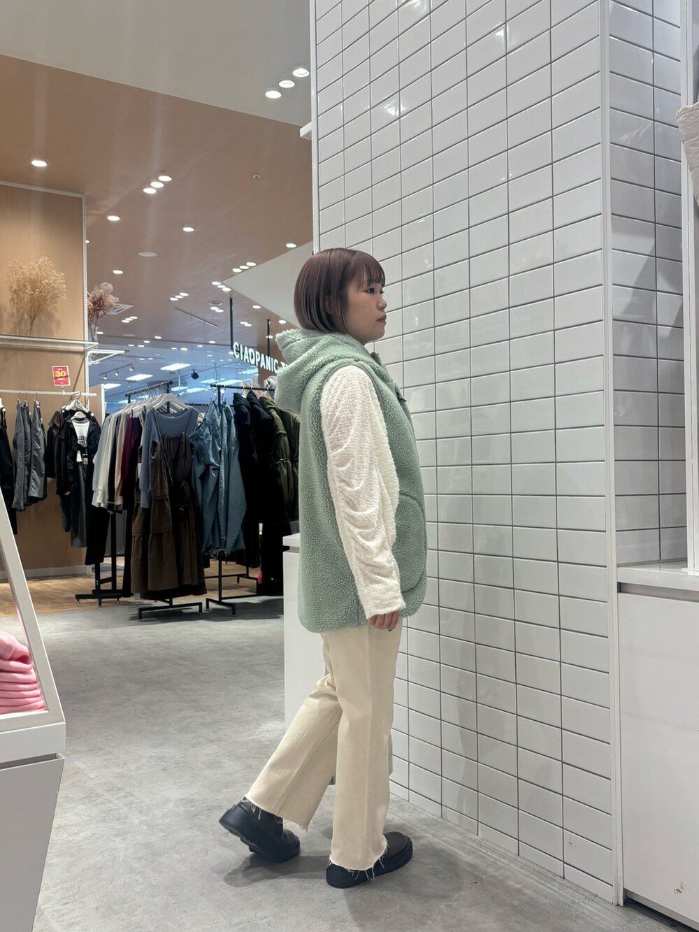 ホワイト系のTシャツ/カットソー、ホワイト系のデニムパンツ、ブラウン系のブーツを着用したレディースの秋コーディネートの2枚目の写真