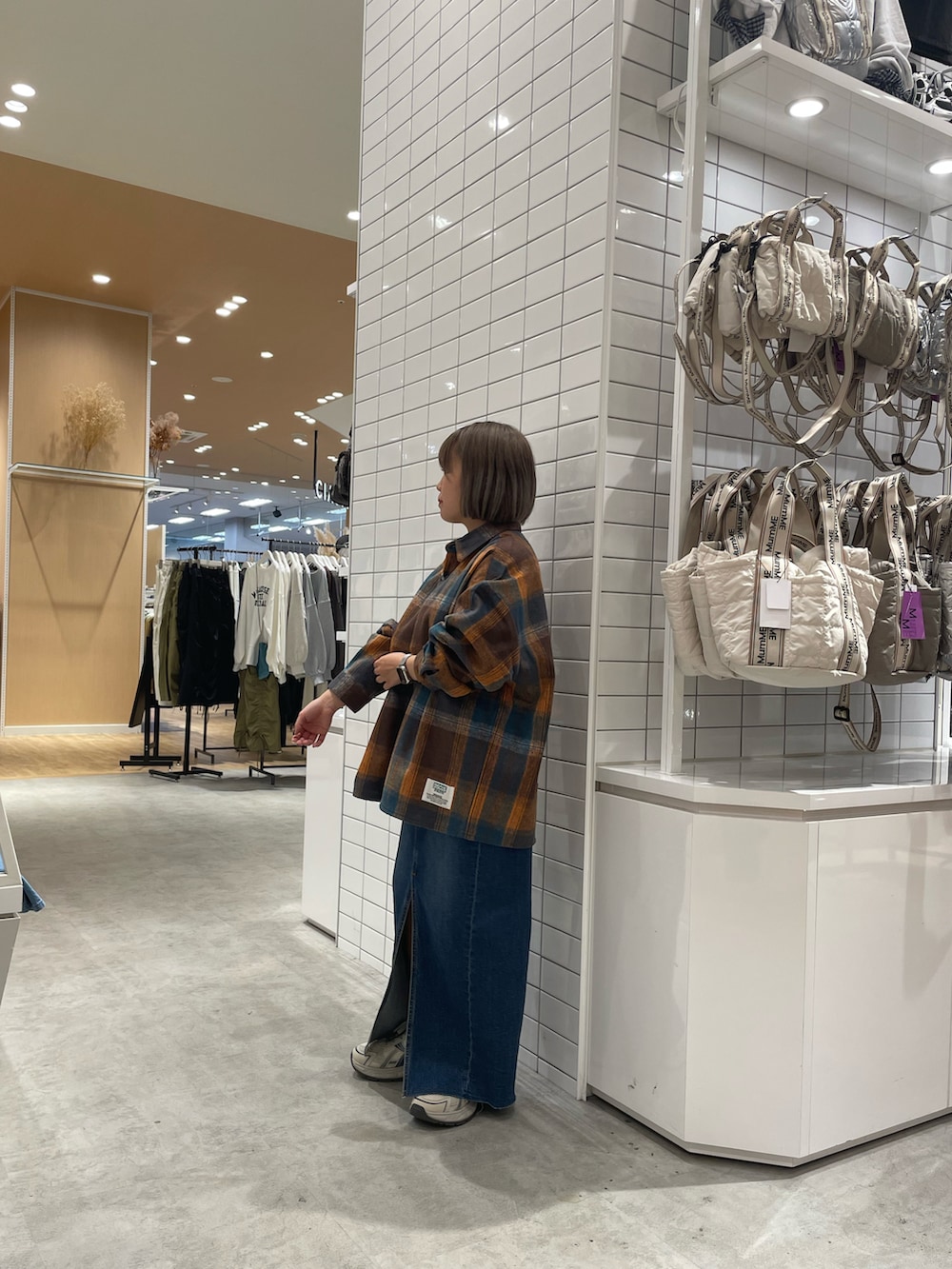 オレンジ系のシャツ/ブラウス、ブルー系のデニムスカート、ホワイト系のスニーカーを着用したレディースの秋コーディネートの3枚目の写真