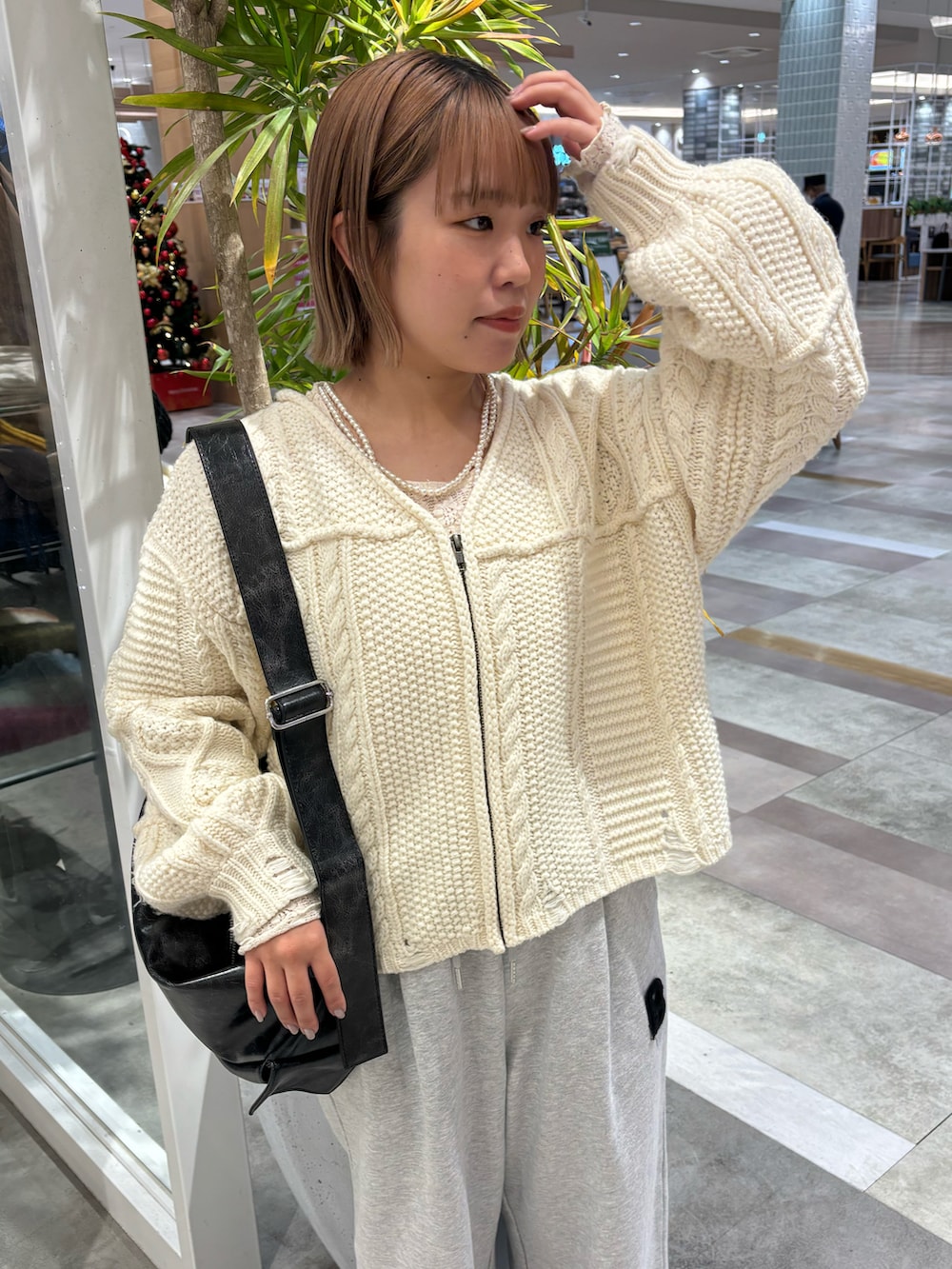 ブラック系のショルダーバッグ、グレー系のスウェットパンツ、ブラック系のブーツを着用したレディースの春コーディネートの2枚目の写真