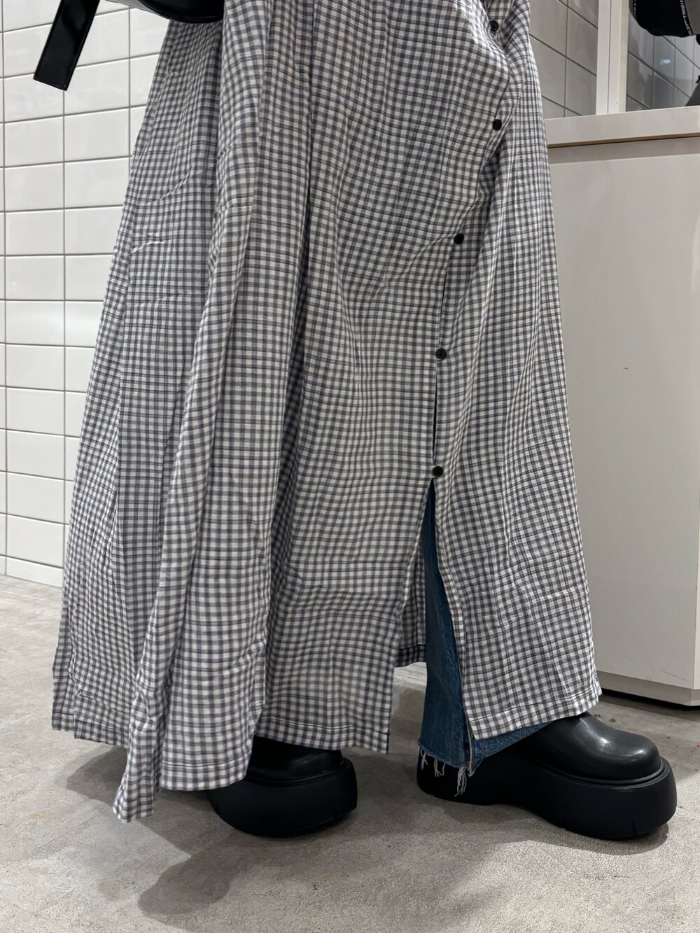 ホワイト系のタンクトップ、ブラック系のショルダーバッグ、ブラック系のワンピースを着用したレディースの春コーディネートの5枚目の写真