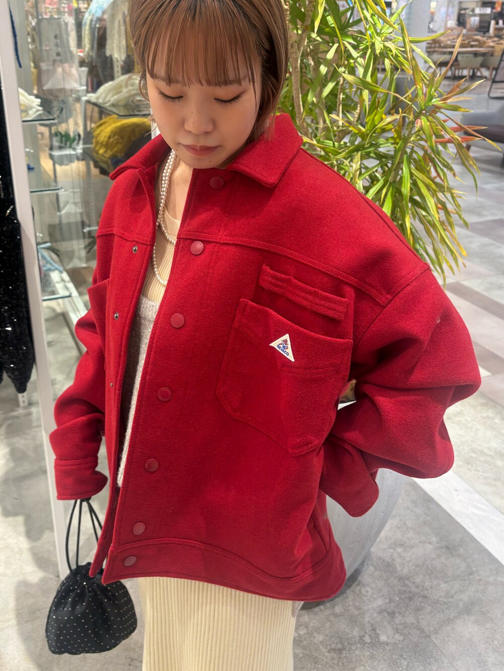 レッド系のその他アウター、ベージュ系のベスト、ホワイト系のスカートを着用したレディースの冬コーディネートの3枚目の写真