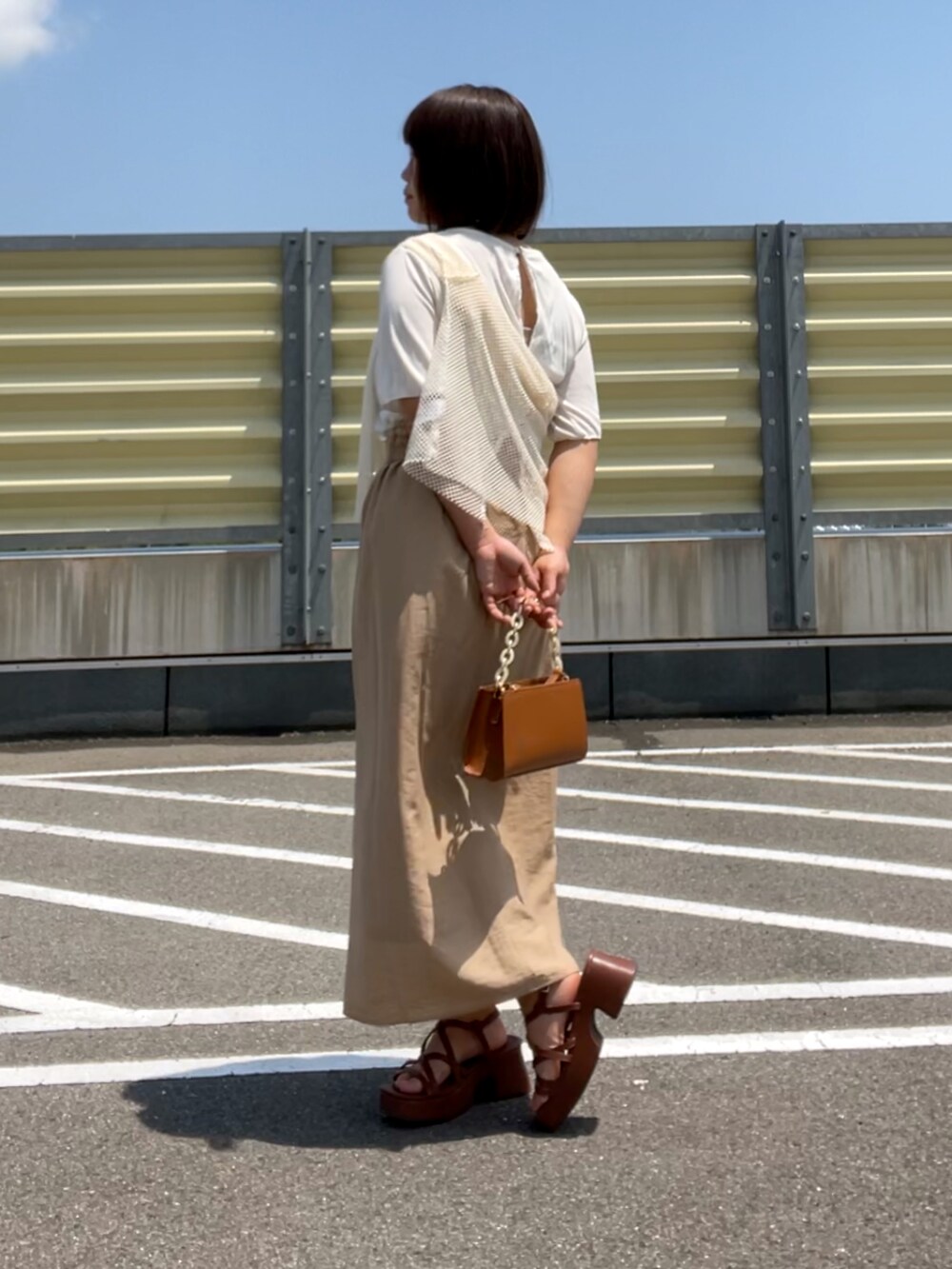 ブラウン系のサンダル、ベージュ系のスカート、ブラウン系のショルダーバッグを着用したレディースの夏コーディネートの4枚目の写真