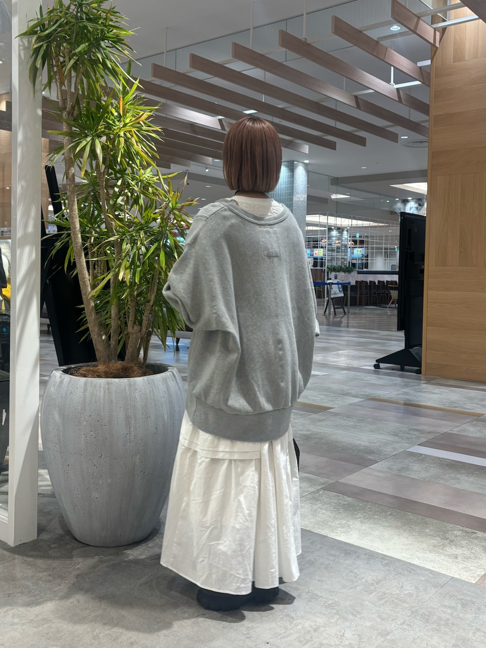 ブラウン系のショルダーバッグ、ホワイト系のワンピース、グレー系のスウェットを着用したレディースの冬コーディネートの4枚目の写真