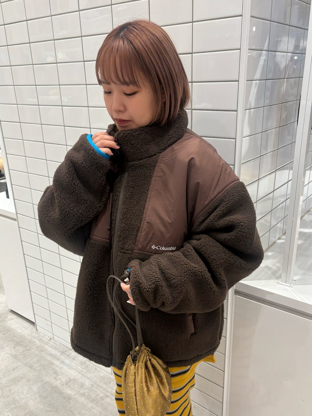 ブラウン系のブルゾン、グリーン系のショルダーバッグ、イエロー系のその他パンツを着用したレディースの秋コーディネートの2枚目の写真