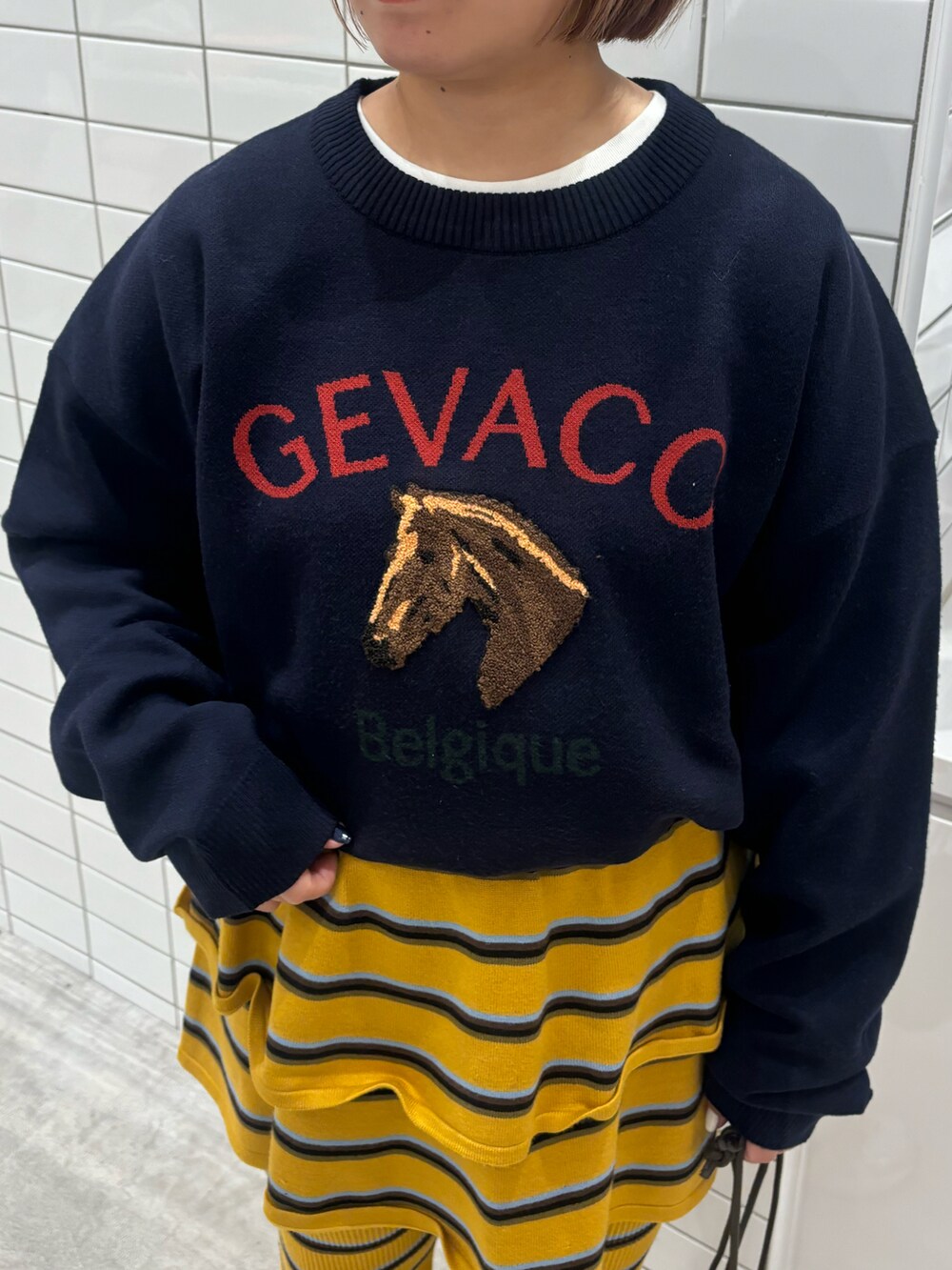 イエロー系のスカート、イエロー系のその他パンツ、グリーン系のショルダーバッグを着用したレディースの冬コーディネートの3枚目の写真