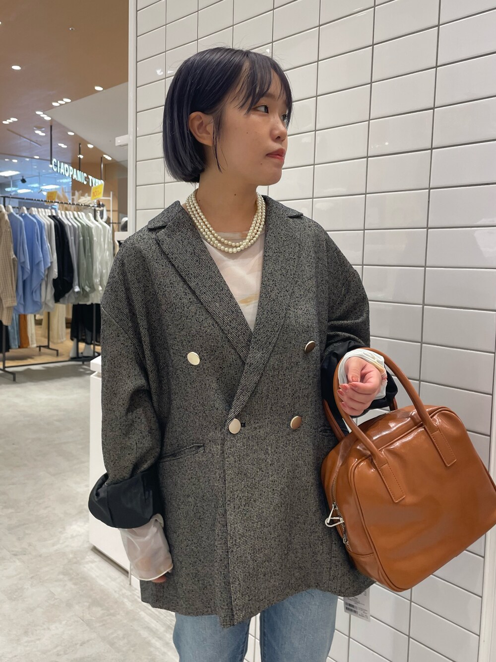 ホワイト系のスニーカー、ホワイト系のTシャツ/カットソー、ブラック系のテーラードジャケットを着用したレディースの秋コーディネートの4枚目の写真