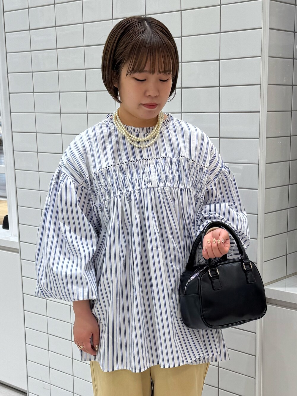 ブルー系のシャツ/ブラウス、ベージュ系のチノパンツ、ブラック系のサンダルを着用したレディースの春コーディネートの4枚目の写真