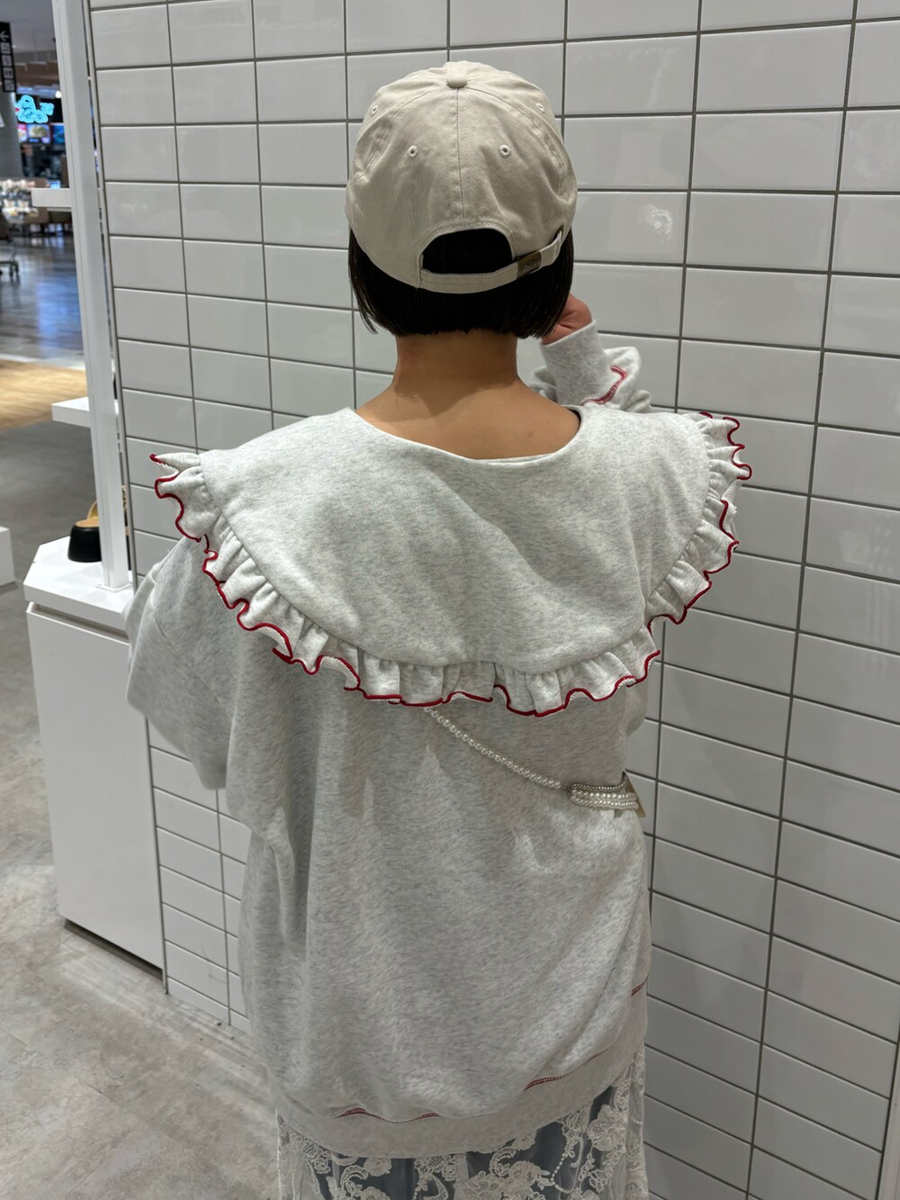 ホワイト系のスカート、ブルー系のデニムパンツ、ブラック系のサンダルを着用したレディースの春コーディネートの3枚目の写真