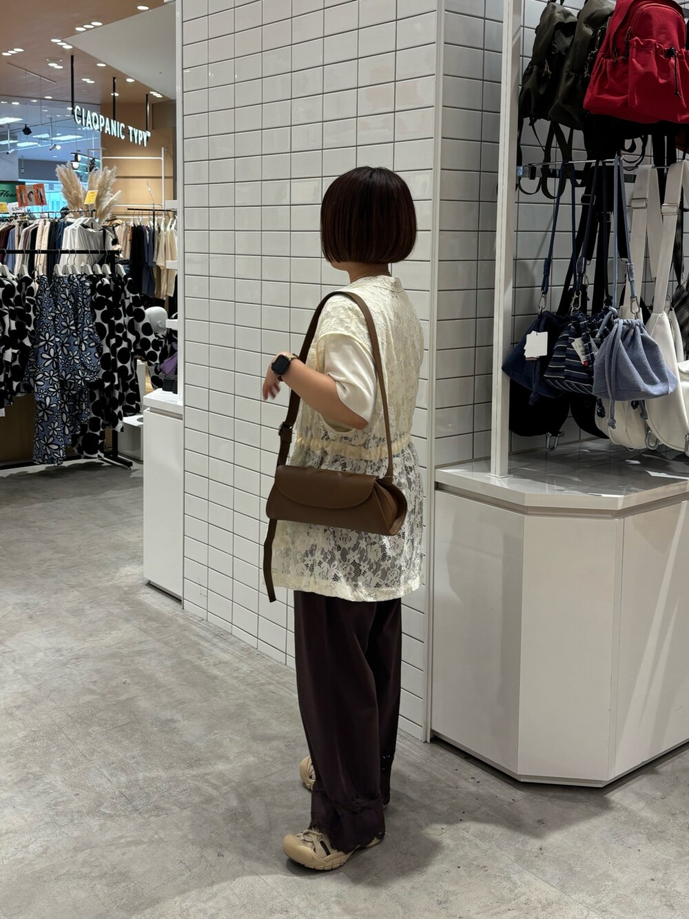 ホワイト系のニット/セーター、ブラウン系のショルダーバッグ、ホワイト系のベストを着用したレディースの夏コーディネートの2枚目の写真