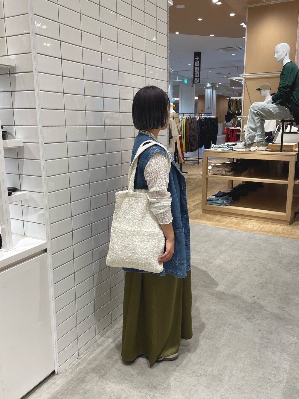 ホワイト系のスニーカー、ホワイト系のTシャツ/カットソー、ブルー系のデニムジャケットを着用したレディースの秋コーディネートの2枚目の写真