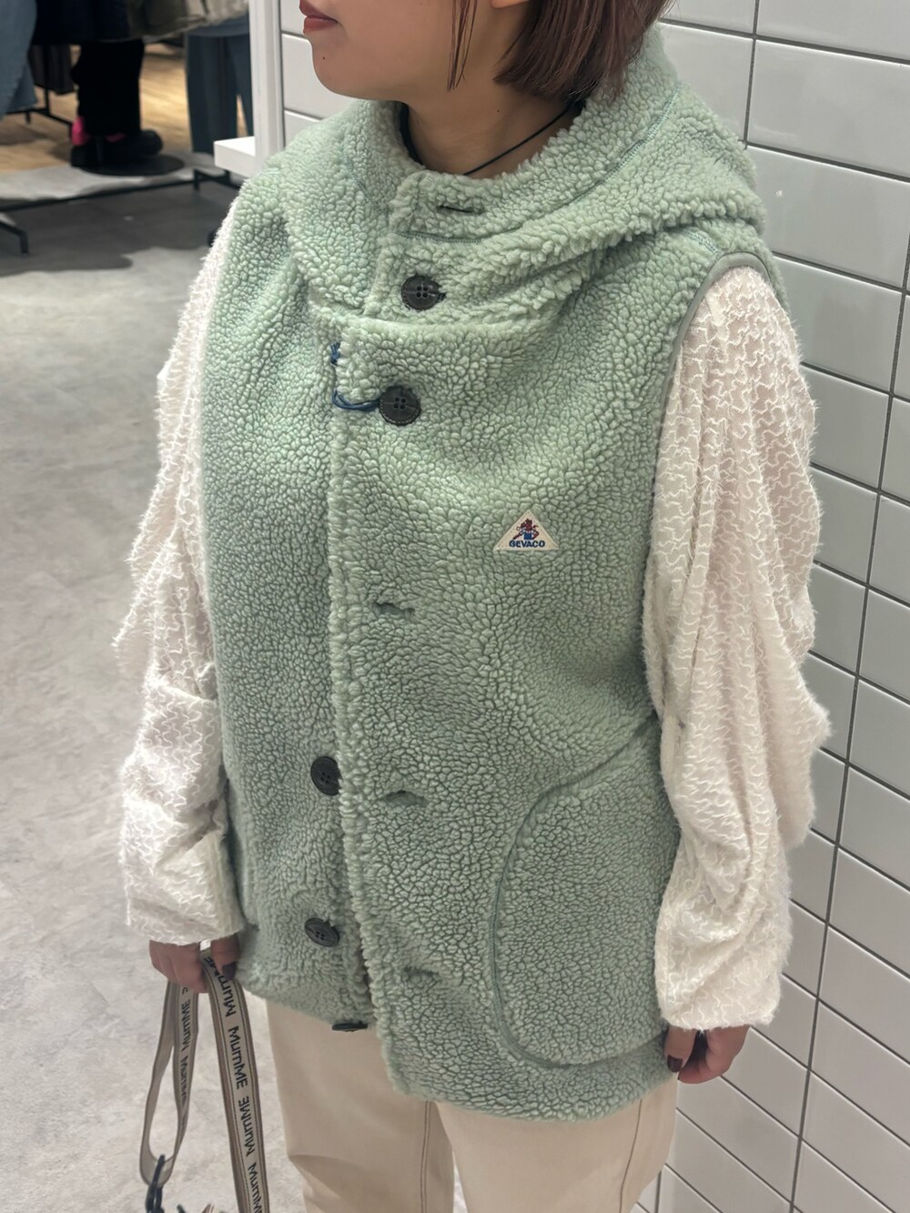 ホワイト系のTシャツ/カットソー、ホワイト系のデニムパンツ、ブラウン系のブーツを着用したレディースの秋コーディネートの4枚目の写真