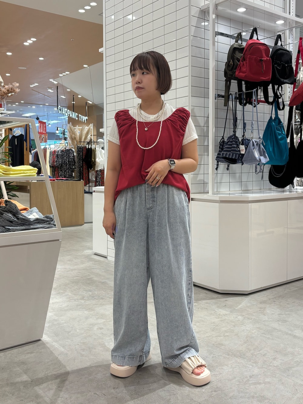 ホワイト系のサンダル、ブルー系のデニムパンツ、レッド系のTシャツ/カットソーを着用したレディースの夏コーディネートの2枚目の写真