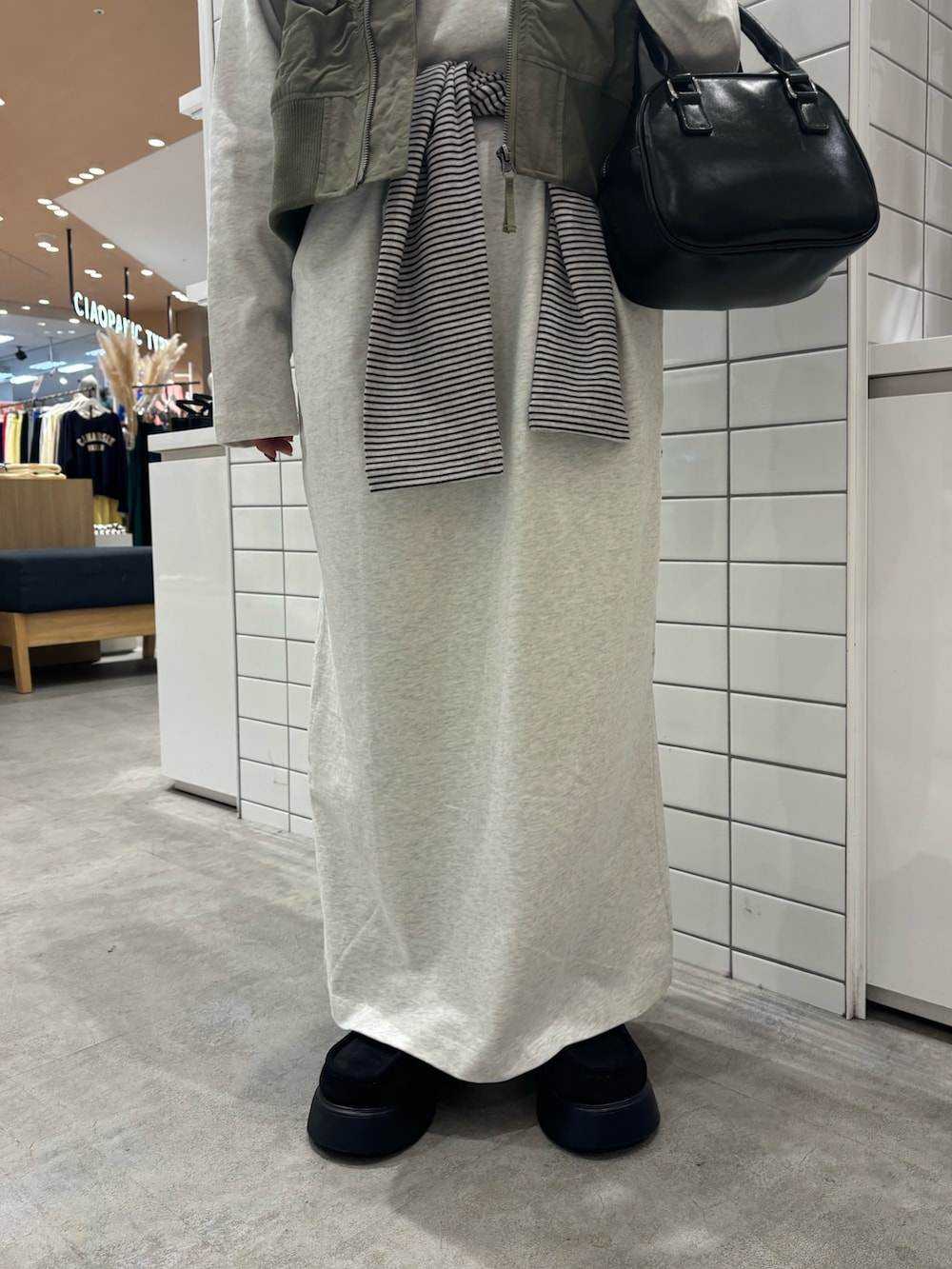 グリーン系のベスト、ブラック系のショルダーバッグ、ブラック系のサンダルを着用したレディースの春コーディネートの5枚目の写真