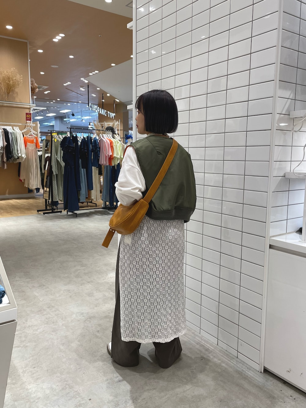 ホワイト系のスニーカー、ホワイト系のTシャツ/カットソー、グリーン系のジャケット/アウターを着用したレディースの秋コーディネートの2枚目の写真