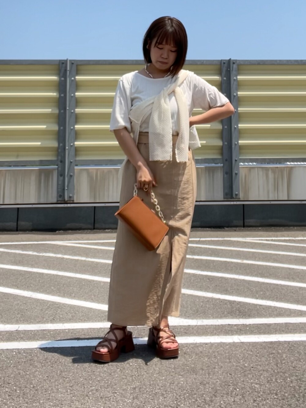 ブラウン系のサンダル、ベージュ系のスカート、ブラウン系のショルダーバッグを着用したレディースの夏コーディネートの3枚目の写真