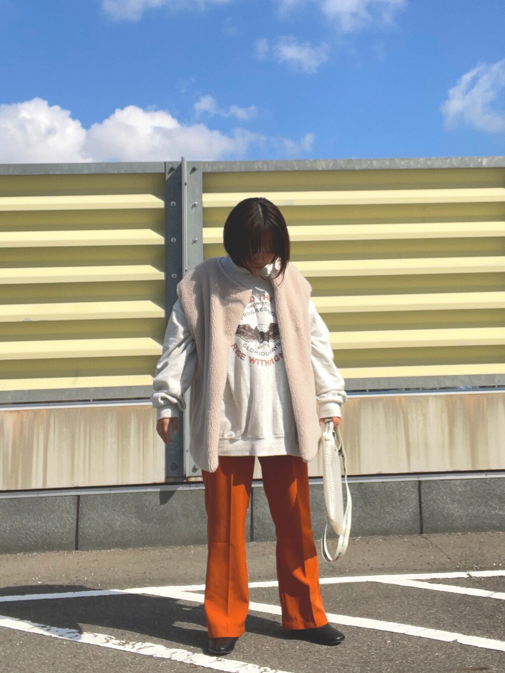 ブラウン系のスラックス、ブラック系のブーツ、その他のショルダーバッグを着用したレディースの冬コーディネートの2枚目の写真