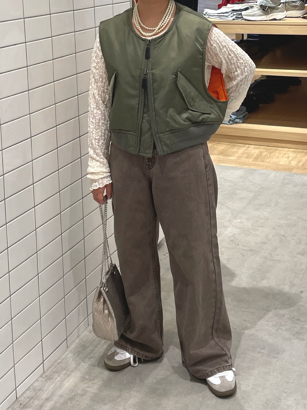 ホワイト系のスニーカー、ホワイト系のTシャツ/カットソー、グリーン系のジャケット/アウターを着用したレディースの秋コーディネートの3枚目の写真