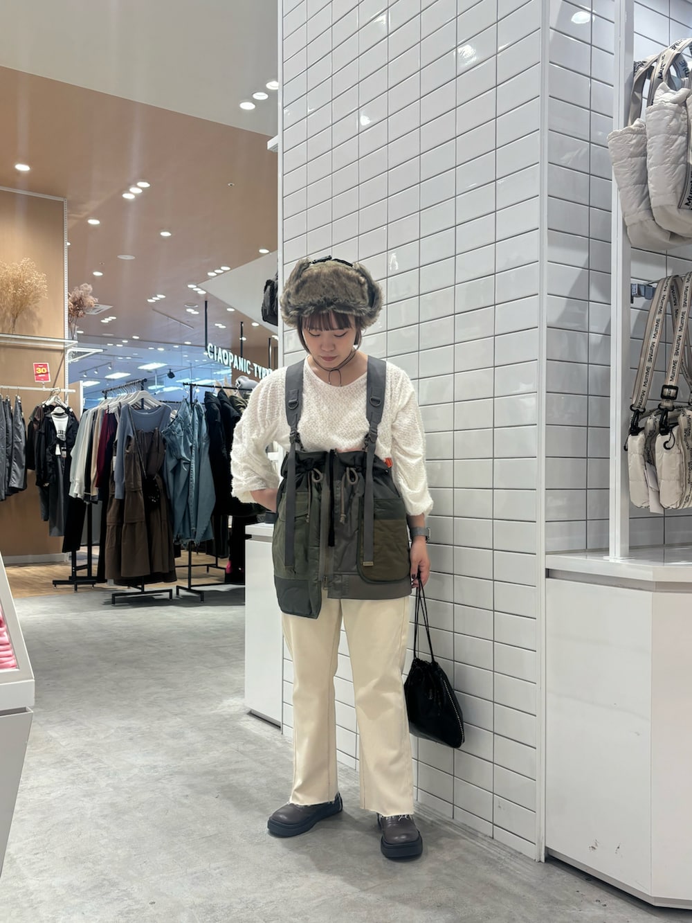 ホワイト系のTシャツ/カットソー、グリーン系のベスト、ブラック系のトートバッグを着用したレディースの秋コーディネートの2枚目の写真