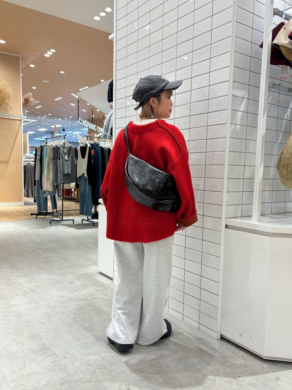 ホワイト系のTシャツ/カットソー、レッド系のカーディガン/ボレロ、グレー系のスウェットパンツを着用したレディースの冬コーディネートの2枚目の写真