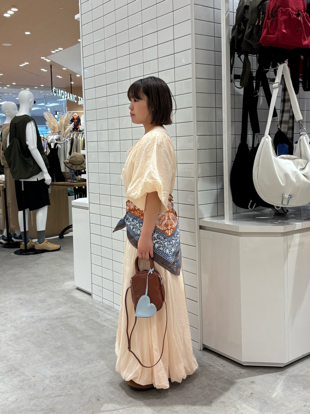 ホワイト系のワンピース、ブラウン系のトートバッグ、ホワイト系のタンクトップを着用したレディースの夏コーディネートの2枚目の写真