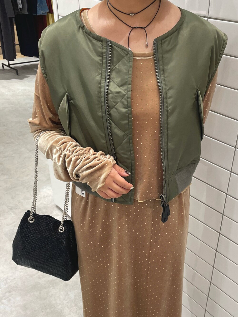 グリーン系のジャケット/アウター、ベージュ系のTシャツ/カットソー、ベージュ系のスカートを着用したレディースの秋コーディネートの4枚目の写真