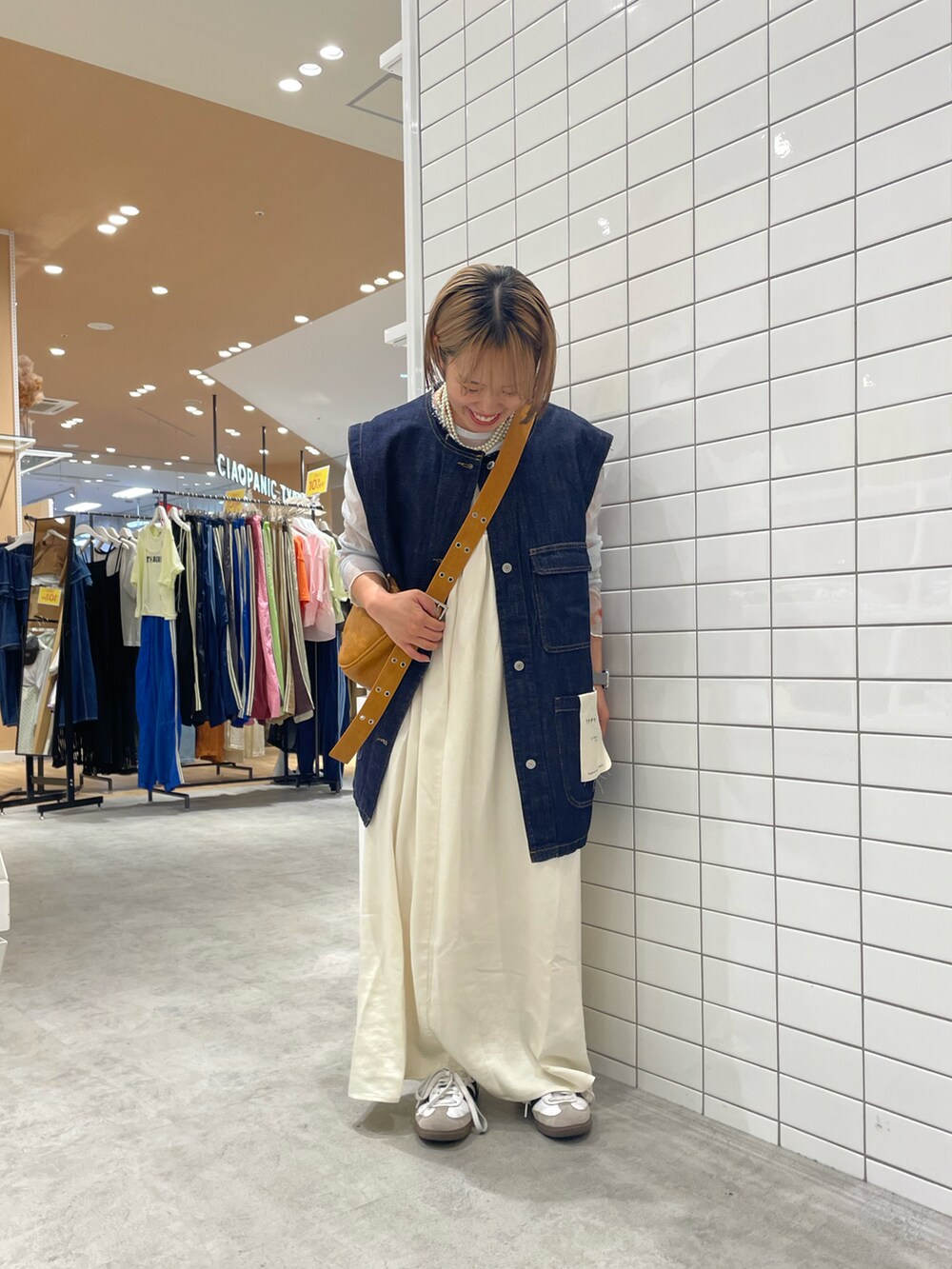 ホワイト系のスニーカー、ホワイト系のTシャツ/カットソー、ブルー系のデニムジャケットを着用したレディースの秋コーディネートの2枚目の写真