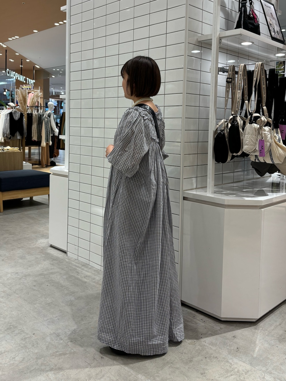 ホワイト系のタンクトップ、ブラック系のショルダーバッグ、ブラック系のワンピースを着用したレディースの春コーディネートの3枚目の写真