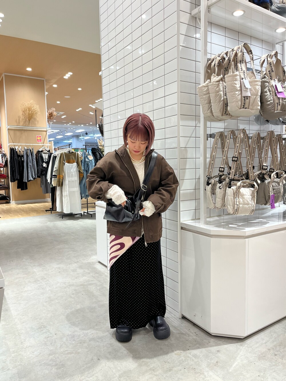 ブラウン系のデニムジャケット、ブラック系のショルダーバッグ、ホワイト系のTシャツ/カットソーを着用したレディースの秋コーディネートの3枚目の写真